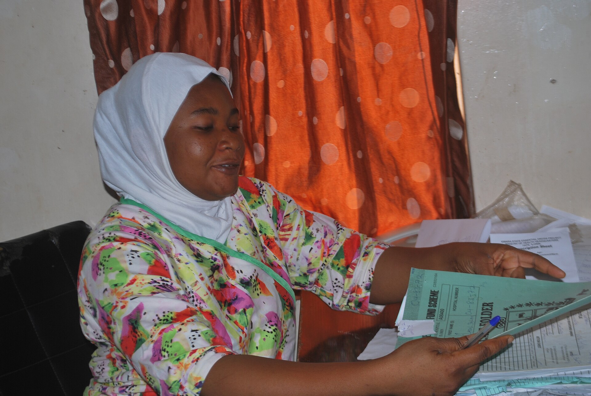 Portrait of a Nigerian nurse in clinical attire.