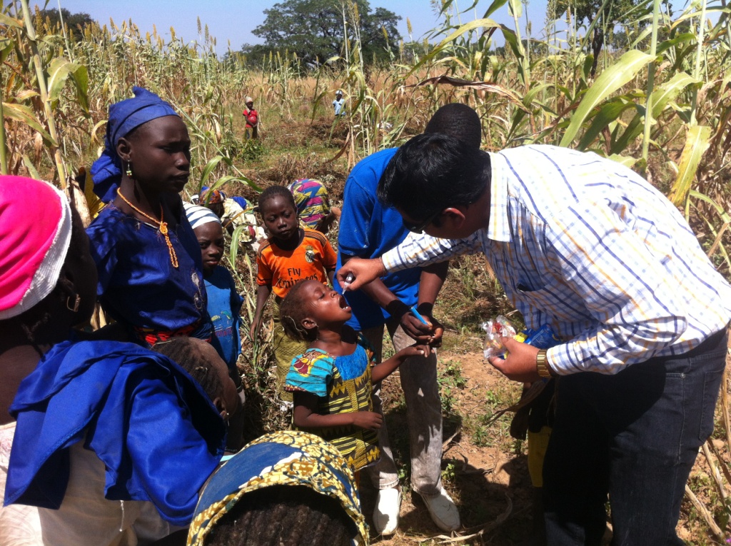 A health worker administering a vaccine in a rural Nigerian farming community.